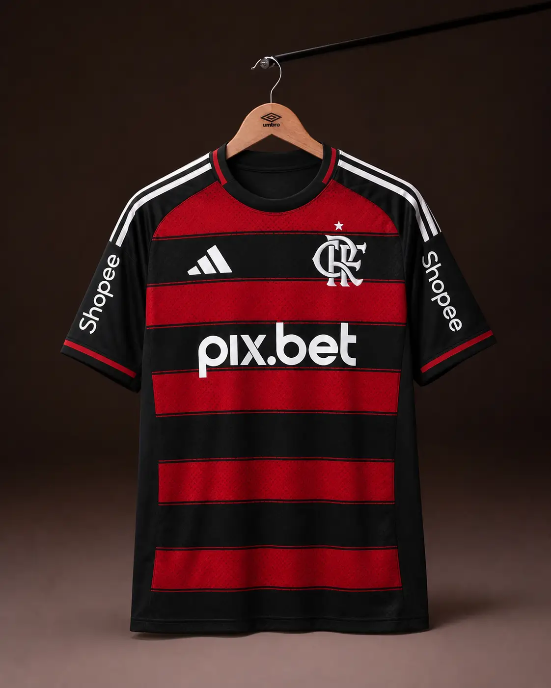 Camisa Flamengo 25/26, rubro-negra, vista de frente em cabide sobre fundo de estudio escuro