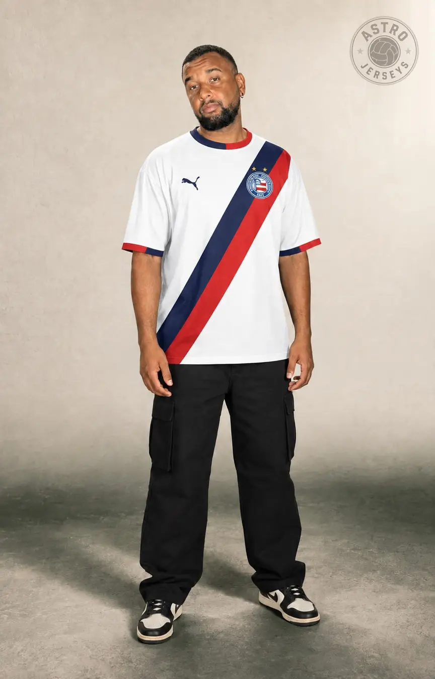 Pessoa de corpo inteiro vestindo a camisa Bahia 26/27, branca, em estúdio de fundo neutro
