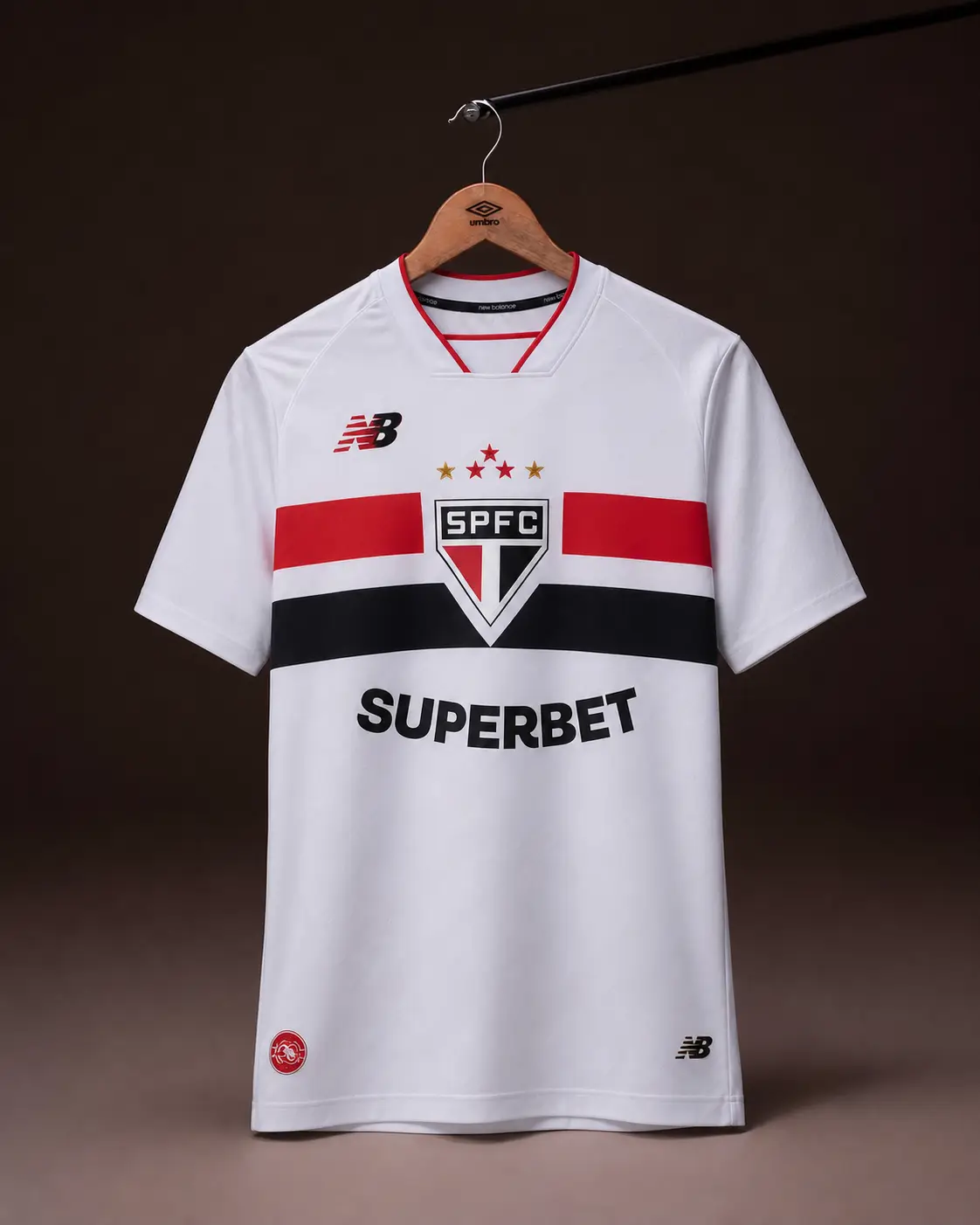 Camisa São Paulo 26/27, tricolor, vista de frente em cabide sobre fundo de estudio escuro