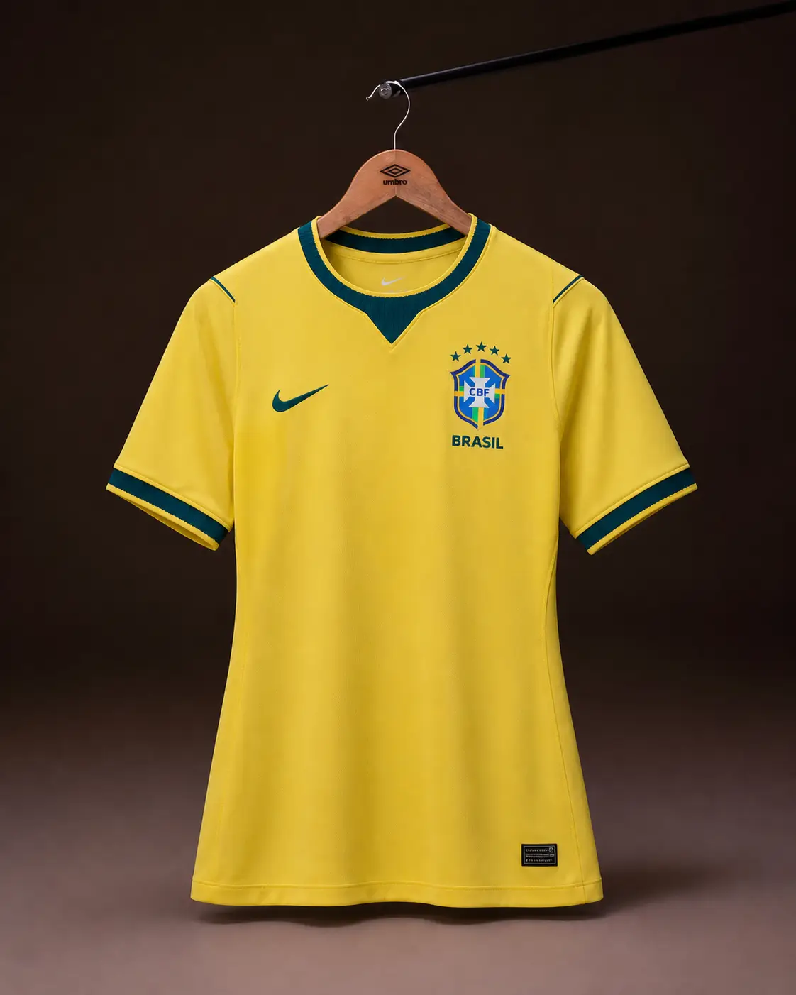 Camisa Brasil Copa 2026, amarela, vista de frente em cabide sobre fundo de estudio escuro