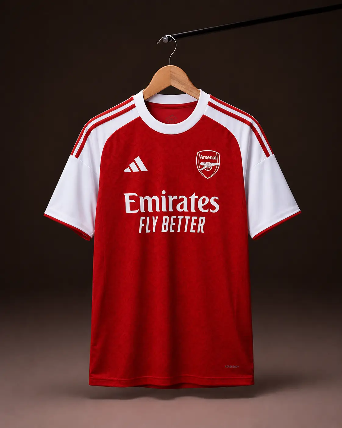 Camisa Arsenal 25/26, vermelha, vista de frente em cabide sobre fundo de estudio escuro