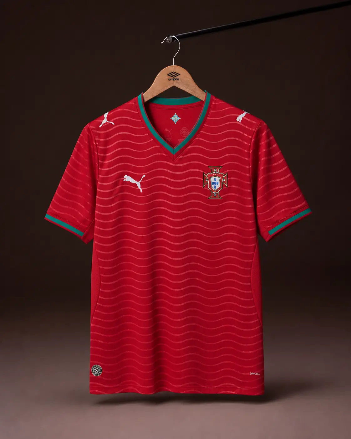 Camisa Portugal Copa 2026, vermelha, vista de frente em cabide sobre fundo de estudio escuro