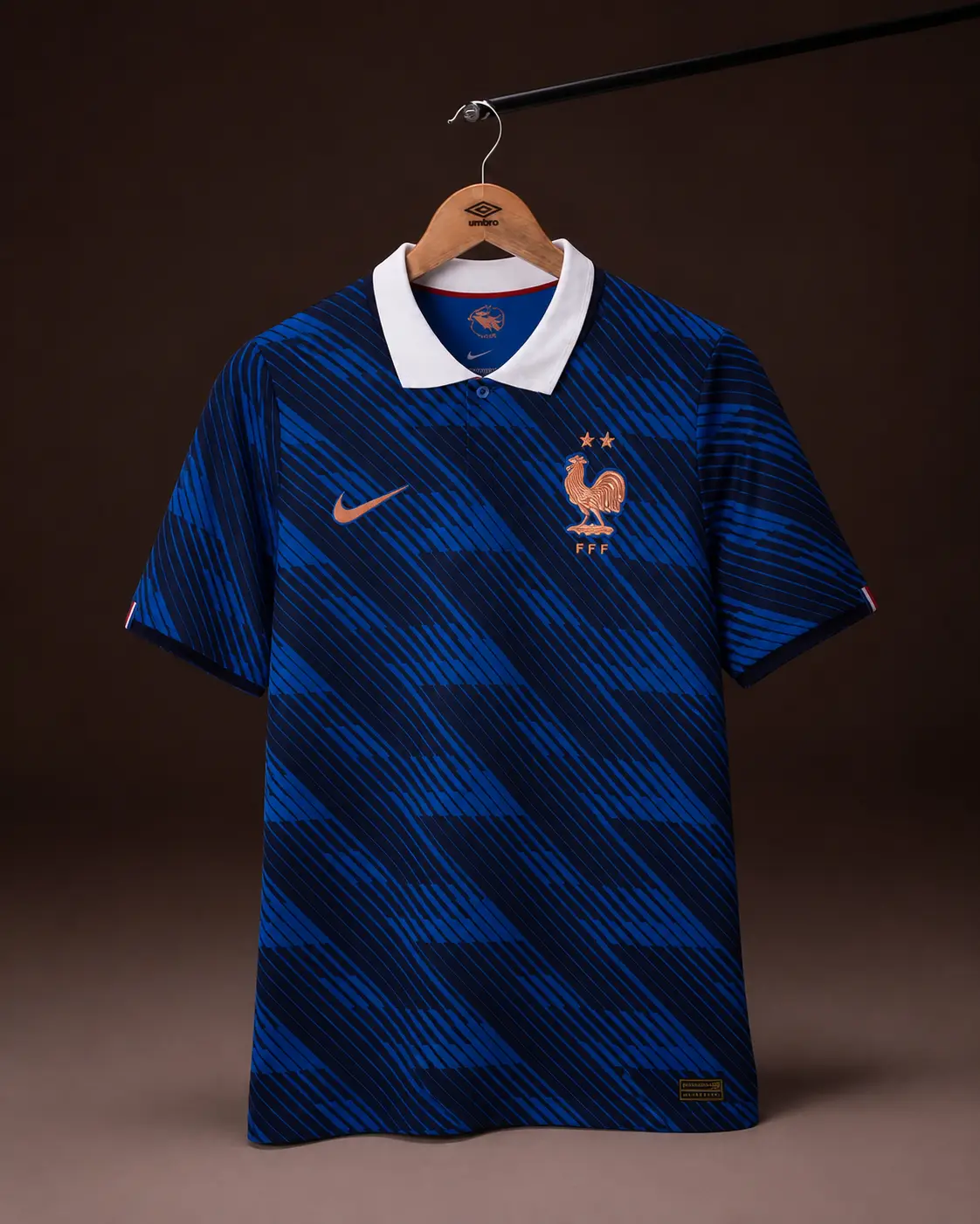 Camisa França Copa 2026, azul, vista de frente em cabide sobre fundo de estudio escuro