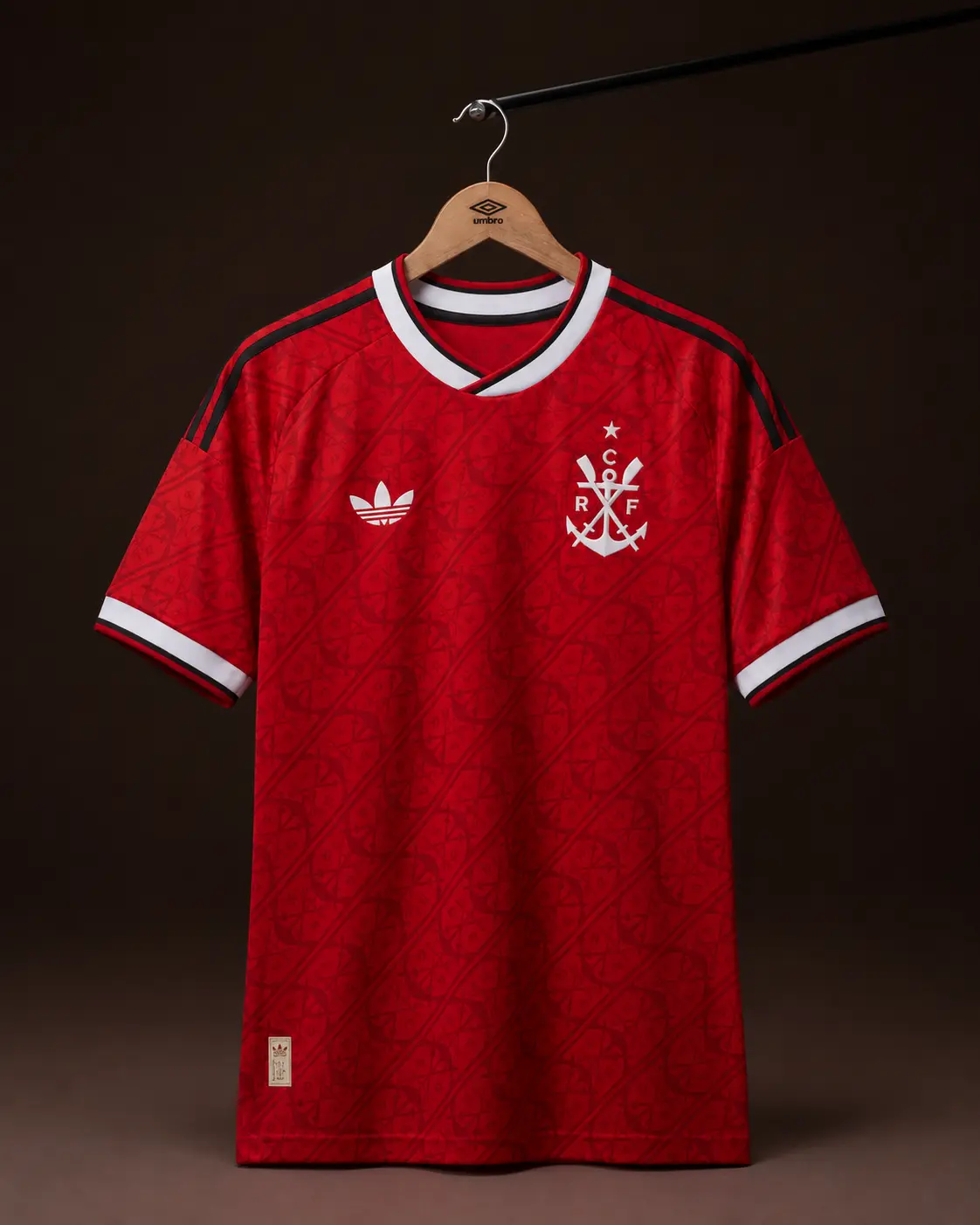 Camisa Flamengo 26/27, vermelha, vista de frente em cabide sobre fundo de estudio escuro