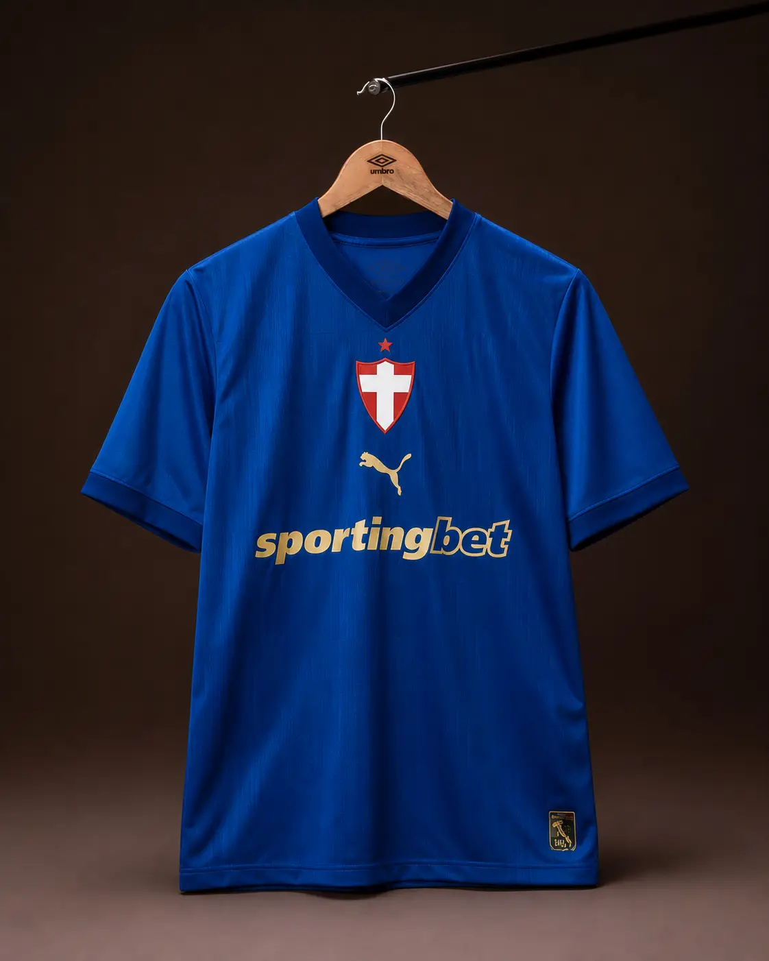 Camisa Palmeiras 26/27, azul, vista de frente em cabide sobre fundo de estudio escuro